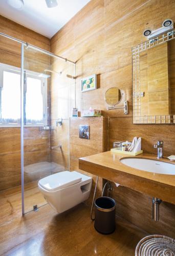 a bathroom with a toilet and a sink and a shower at Karma Chalets in Gurgaon