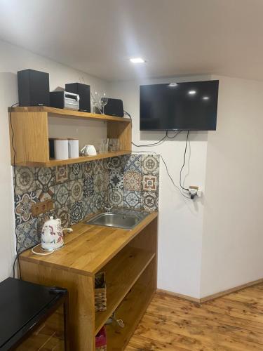 a kitchen with a sink and a tv on the wall at Apartmány MonTexas in Staměřice