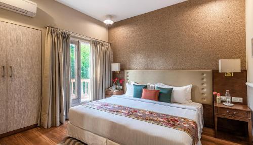 a bedroom with a large bed and a window at Karma Chalets in Gurgaon