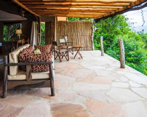 an outdoor patio with a chair and a table at Maasai home village in Sekenani