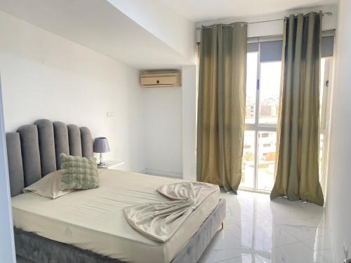 a white bedroom with a large bed and a window at Apartamento sublime c/vista top. in Praia