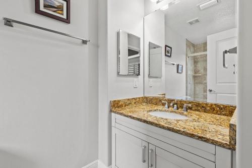 a bathroom with a sink and a mirror at The Wave 302 in New Smyrna Beach