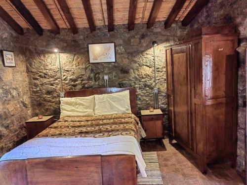 a bedroom with a bed in a stone wall at PITHARIA in Askas