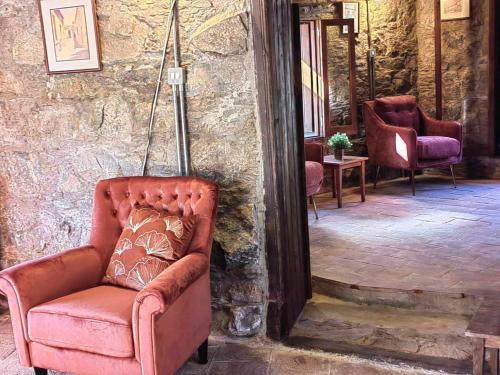 a chair sitting in a room with a stone wall at PITHARIA in Askas