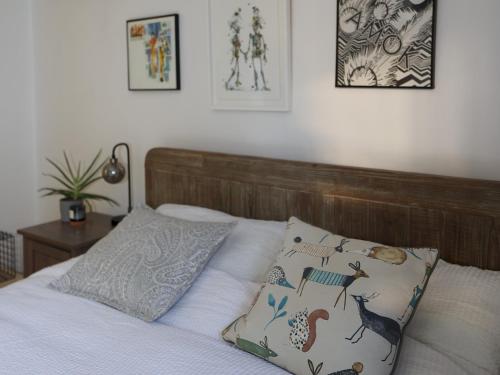 a bed with a wooden headboard and two pillows at Pass the Keys Charming 2 bed apartment in London