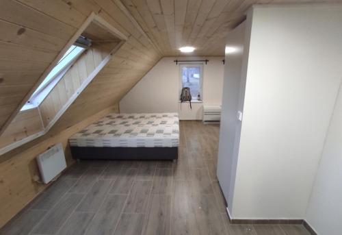 a bedroom with a bed in the middle of a attic at Železnohorské Apartmány u Sečskeho zámku in Seč