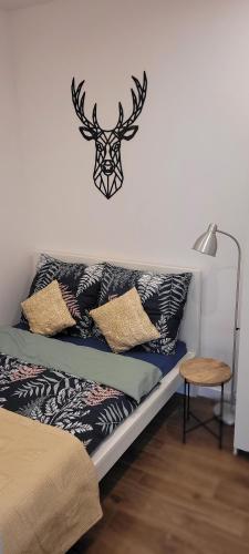 - une chambre avec un lit avec une tête de cerf sur le mur dans l'établissement Apartament z historią, à Jelenia Góra