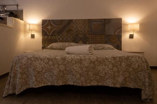 una camera con un letto con una coperta e due lampade di Affittacamere le scale a Castellammare del Golfo