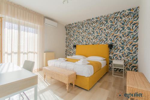 1 dormitorio con 1 cama grande con una pared colorida en Einaudi Guesthouse by Apulia Accommodation, en Bari
