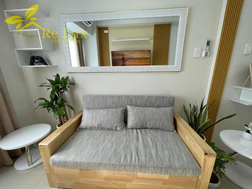 a couch in a living room with a mirror at Re Lux Staycation, NEAR NAIA in Manila