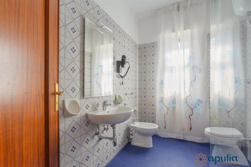 y baño con lavabo, aseo y espejo. en Einaudi Guesthouse by Apulia Accommodation, en Bari