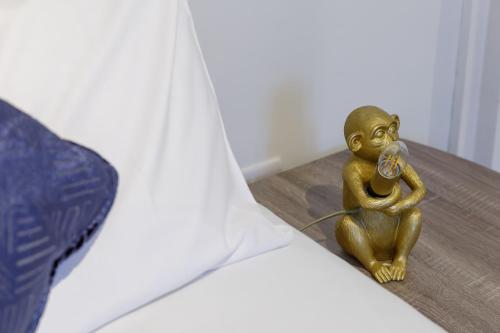 małą figurkę z mosiądzu siedzącą na podłodze z telefonem w obiekcie Central 6 bedroom townhouse w Brighton and Hove