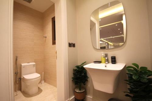 a bathroom with a sink and a toilet and a mirror at شقة ارضية واسعة Spacious Ground Floor Apartment in Riyadh