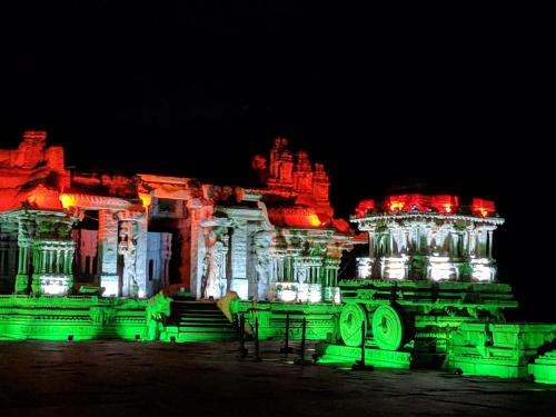 a building lit up at night with green lights at Hotel Varsha Hampi in Hampi