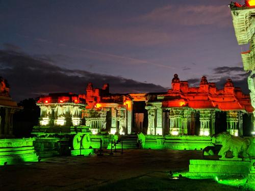 a building lit up at night with green lights at Hotel Varsha Hampi in Hampi