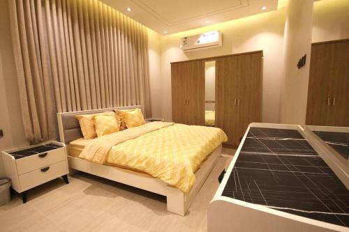 a bedroom with a bed with a yellow comforter at شقة ارضية واسعة Spacious Ground Floor Apartment in Riyadh