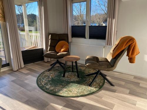 een woonkamer met 2 stoelen en een tafel bij Villetta Verde in Heusden