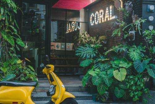 a yellow scooter parked in front of a store at Coral B&B in Xiaoliuqiu