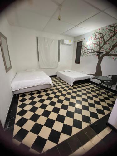 Zimmer mit 2 Betten auf einem karierten Boden in der Unterkunft VEGAN GARDEN HOSTAL in Barranquilla