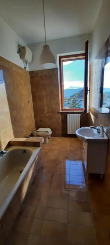 ein Badezimmer mit zwei Waschbecken, einer Badewanne und einem WC in der Unterkunft Affittacamere DANIELA in Castelbellino