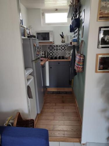 une petite cuisine avec un réfrigérateur et un évier dans l'établissement L'Estaca Maison de pêcheur avec jardin bord de mer, à Étretat