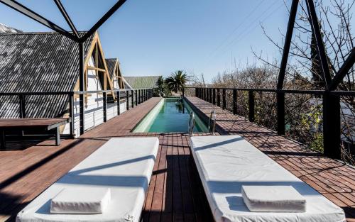 a wooden deck with a swimming pool on a house at Mousai Hotel Boutique in Capilla del Monte