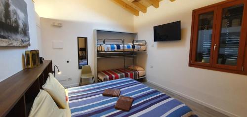 a bedroom with two bunk beds and a television at Relais des Roches in Sona