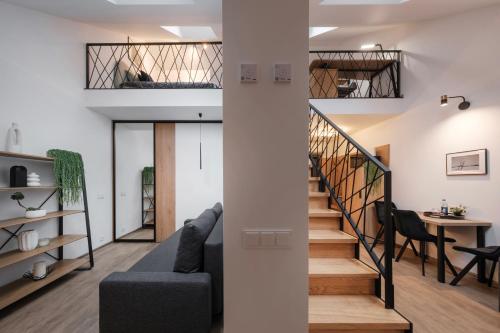 a living room with a staircase and a table at Butas-loftas mieste, Kaunas in Kaunas