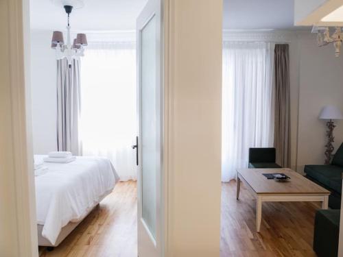 a bedroom with a bed and a couch and a table at Filigran II-Stylish Apartment with Free Parking in Ioannina