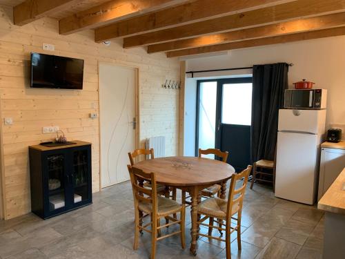 a kitchen with a table and chairs and a refrigerator at Gîte du Redondet in Cisternes-la-Forêt