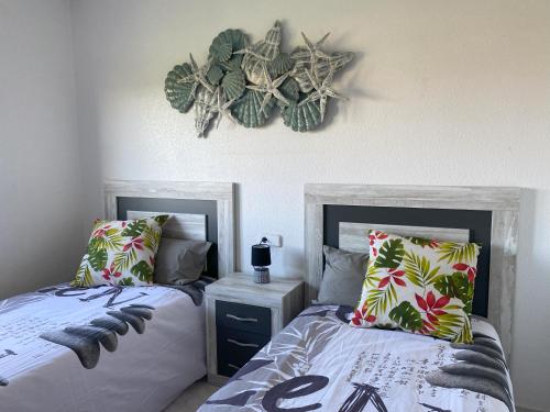 1 dormitorio con 2 camas y zona de estar en la pared en Greensuites La Zenia Torrevieja, en Playa Flamenca