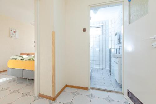 a bathroom with a shower and a bed in a room at Willa Bryza in Niechorze