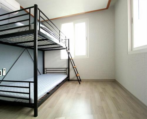 a room with two bunk beds and a window at Moonlight Hill Guesthouse in Mokpo