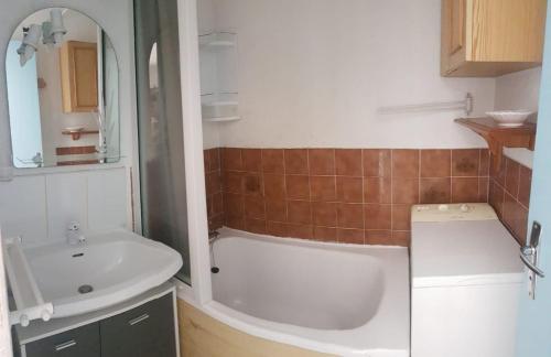een badkamer met een bad en een wastafel bij T2 sur le port avec parking in Gruissan