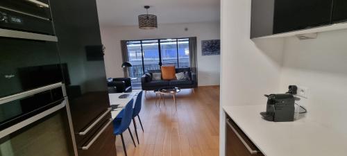 une cuisine et un salon avec une table et des chaises dans l'établissement BEL APPARTEMENT CONTEMPORAIN avec TERRASSE CLIMATISATION et PARKING payant en option, à Strasbourg