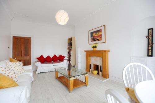 uma sala de estar com dois sofás brancos e uma lareira em Flat 6 em Edinburgo
