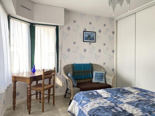 een slaapkamer met een bed, een tafel en een stoel bij 522 - A Erquy dans une résidence calme à 200m de la Plage in Erquy