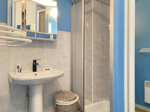 een witte badkamer met een wastafel en een douche bij 522 - A Erquy dans une résidence calme à 200m de la Plage in Erquy
