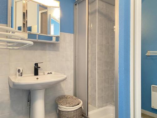 une salle de bain blanche avec un lavabo et une douche dans l'établissement 522 - A Erquy dans une résidence calme à 200m de la Plage, à Erquy