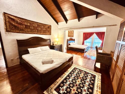 a bedroom with a large bed and a living room at The White Horse in Cameron Highlands