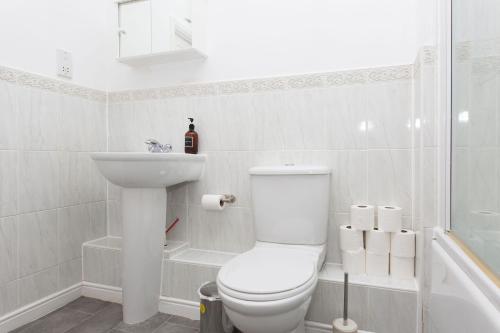 a white bathroom with a toilet and a sink at Seager Apartments, Comfortable Cardiff Bay Apartment in Cardiff