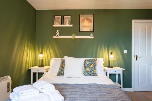 a bedroom with green walls and a bed with two tables at Seager Apartments, Comfortable Cardiff Bay Apartment in Cardiff