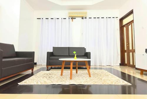 sala de estar con mesa y sofá en Elrad Residence Villa by Monalisa, en Morogoro