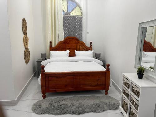 1 dormitorio con cama de madera y ventana en Nashu House Stone Town en Ngambo