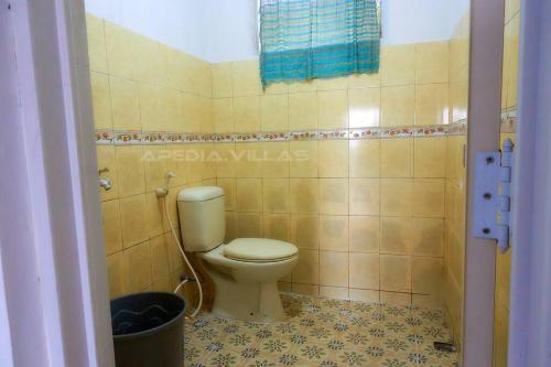 a bathroom with a toilet in a tiled room at Villa DBusso Apedia, 3 BR, SP, Billiard, Karaoke in Kopo 2