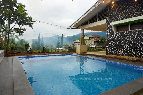 a swimming pool in front of a house at Villa DBusso Apedia, 3 BR, SP, Billiard, Karaoke in Kopo 2