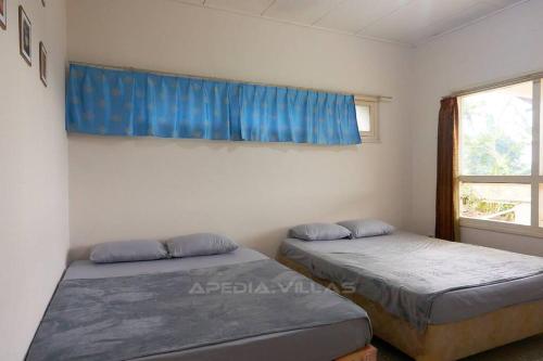 two beds in a room with a window at Villa DBusso Apedia, 3 BR, SP, Billiard, Karaoke in Kopo 2
