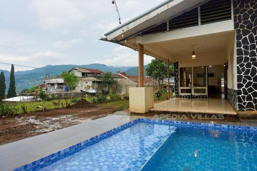 a swimming pool in front of a house at Villa DBusso Apedia, 3 BR, SP, Billiard, Karaoke in Kopo 2
