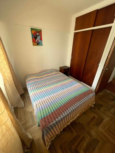 1 dormitorio con 1 cama y suelo de madera en 2 AMBIENTES A METROS DE LA PLAYA LA PERLA en Mar del Plata