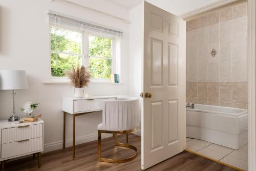 een badkamer met een bureau, een wastafel en een bad bij Snowdrop - Connect to the Nature in the Hot Tub in Blandford Forum
